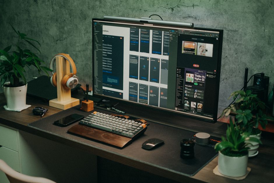 Sleek home office setup s velikim monitorom, tastaturom i biljkama